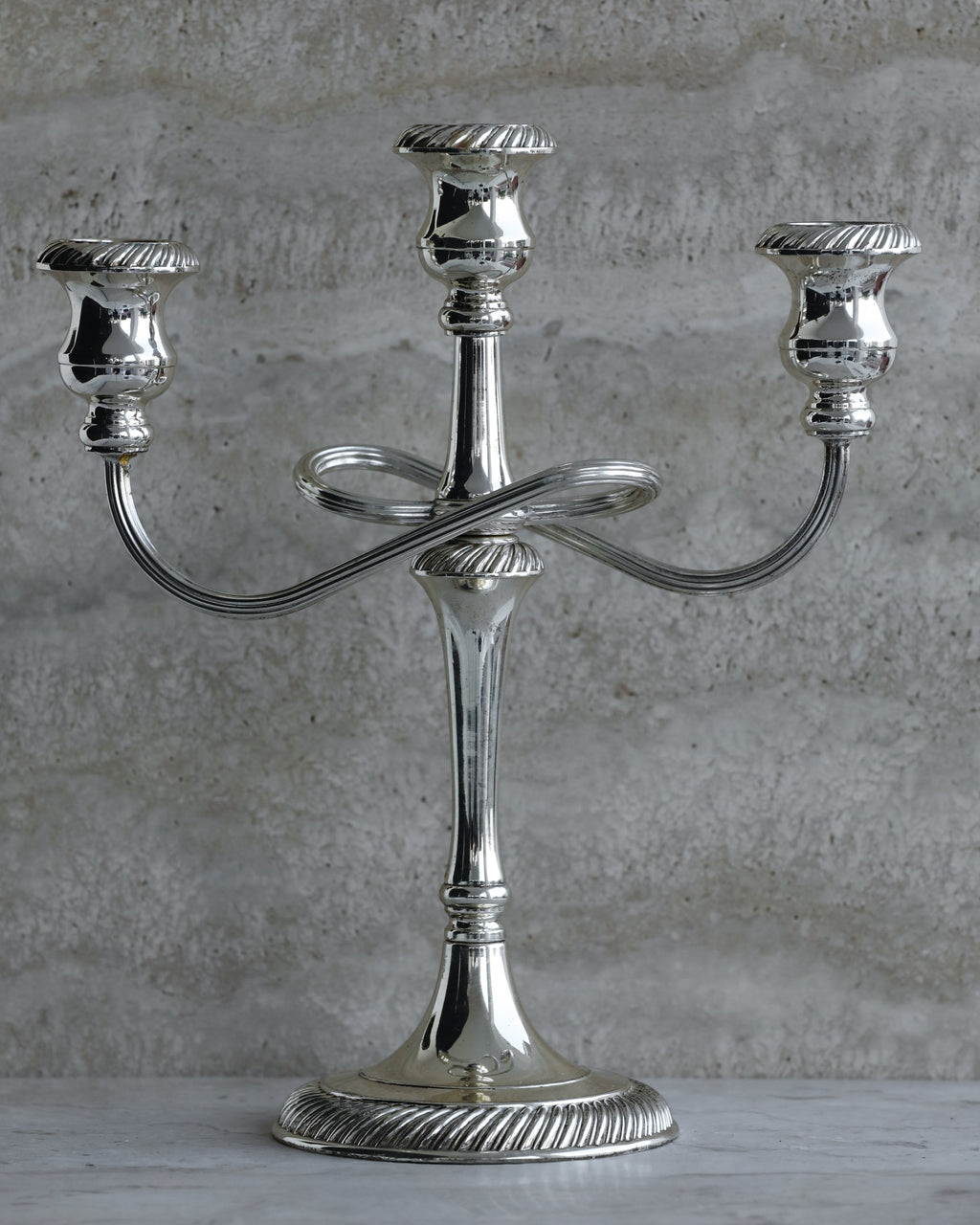 Vintage Italian silver plated three arm candelabra from the 1970s on stone surface