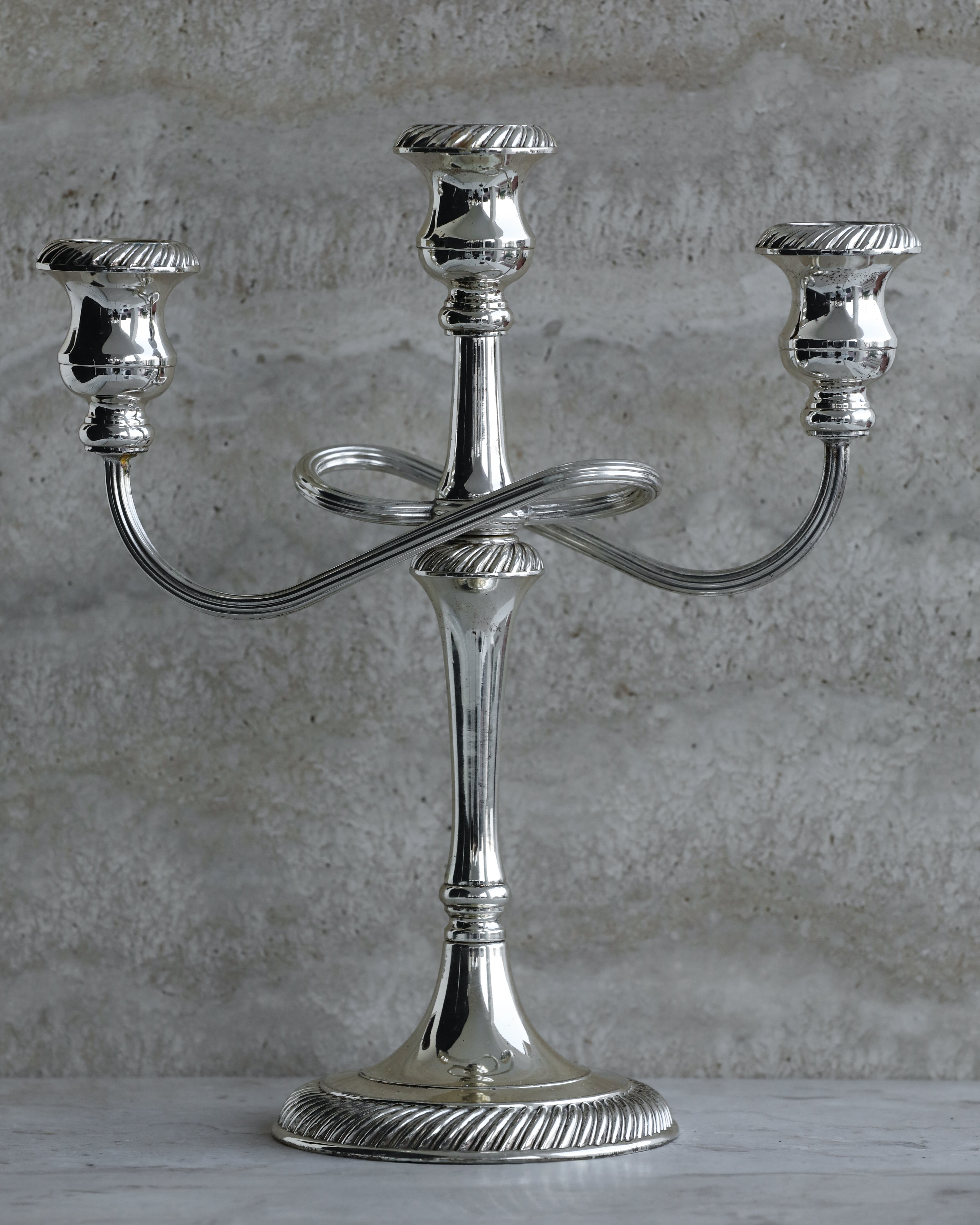 Vintage Italian silver plated three arm candelabra from the 1970s on stone surface