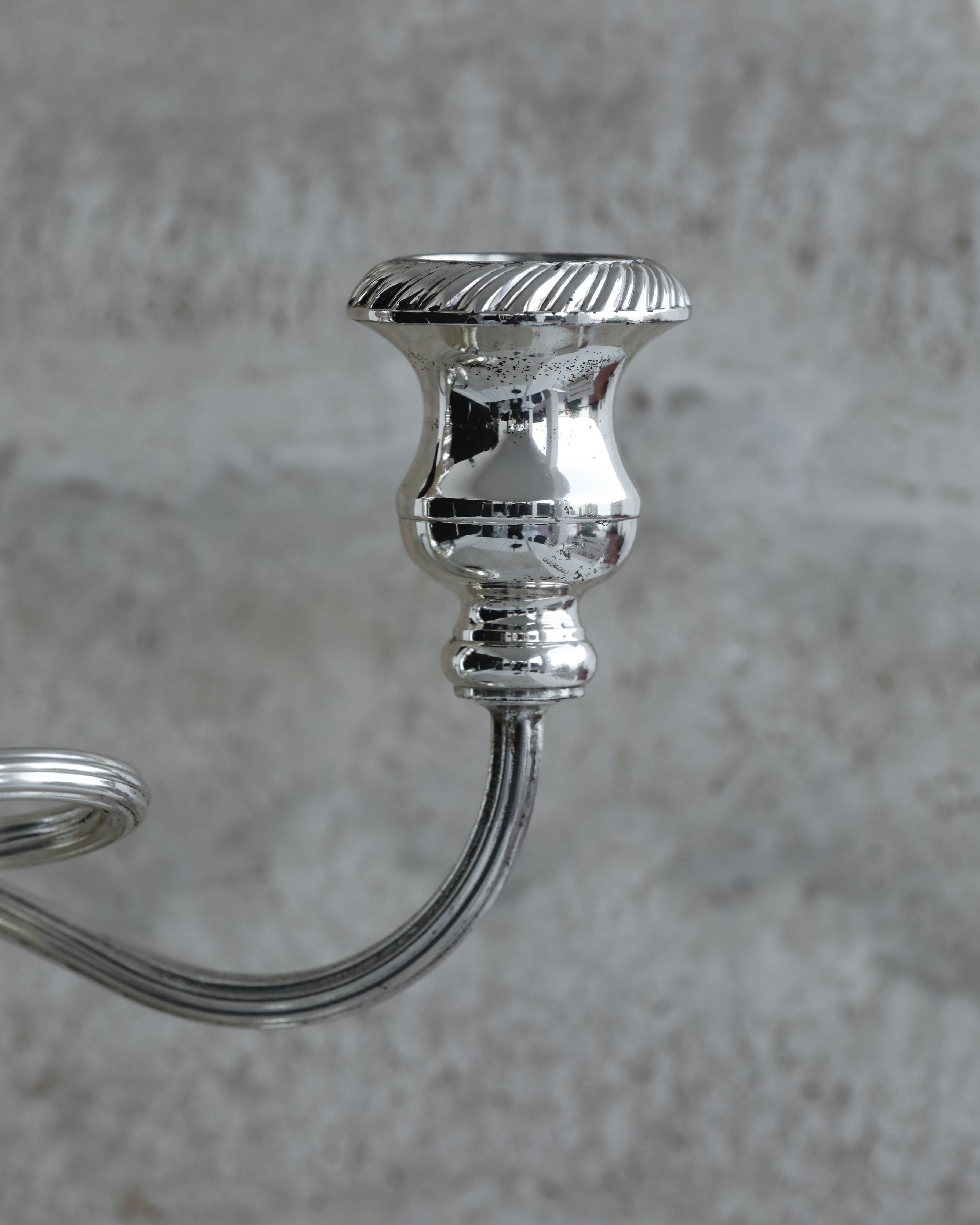 Side view of curved arm and candle holder in silver plated Italian candelabra