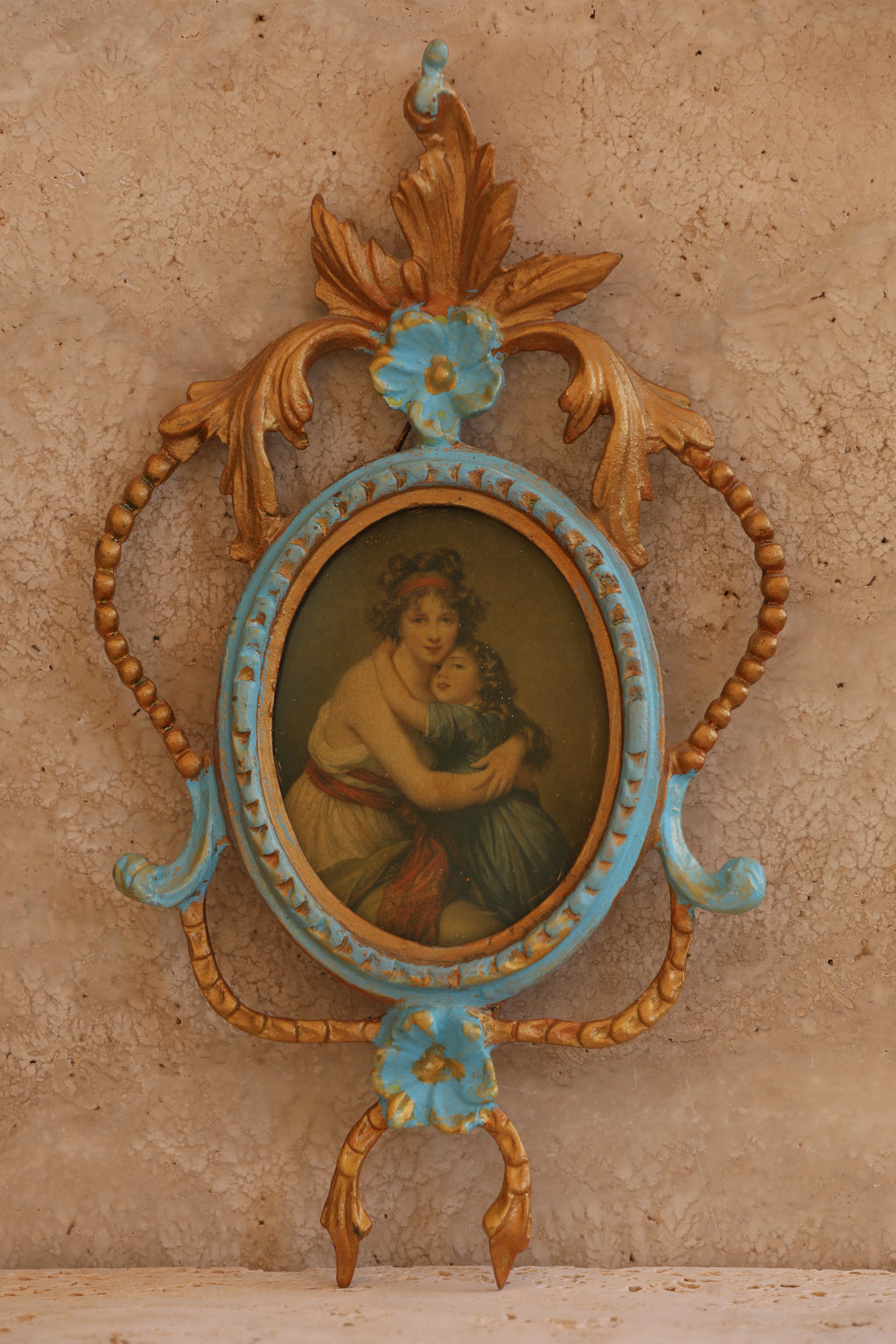 Close-up of ornate Italian brass picture frame with hand-painted miniature portrait in rococo floral design