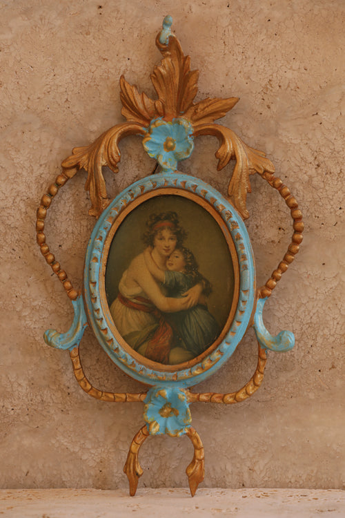 Close-up of ornate Italian brass picture frame with hand-painted miniature portrait in rococo floral design