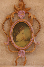 Close-up of vintage Italian brass frame with lavender floral detailing and oval portrait under convex glass