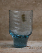 Ribbed cobalt blue tumbler glass with flared base and vertical texture.