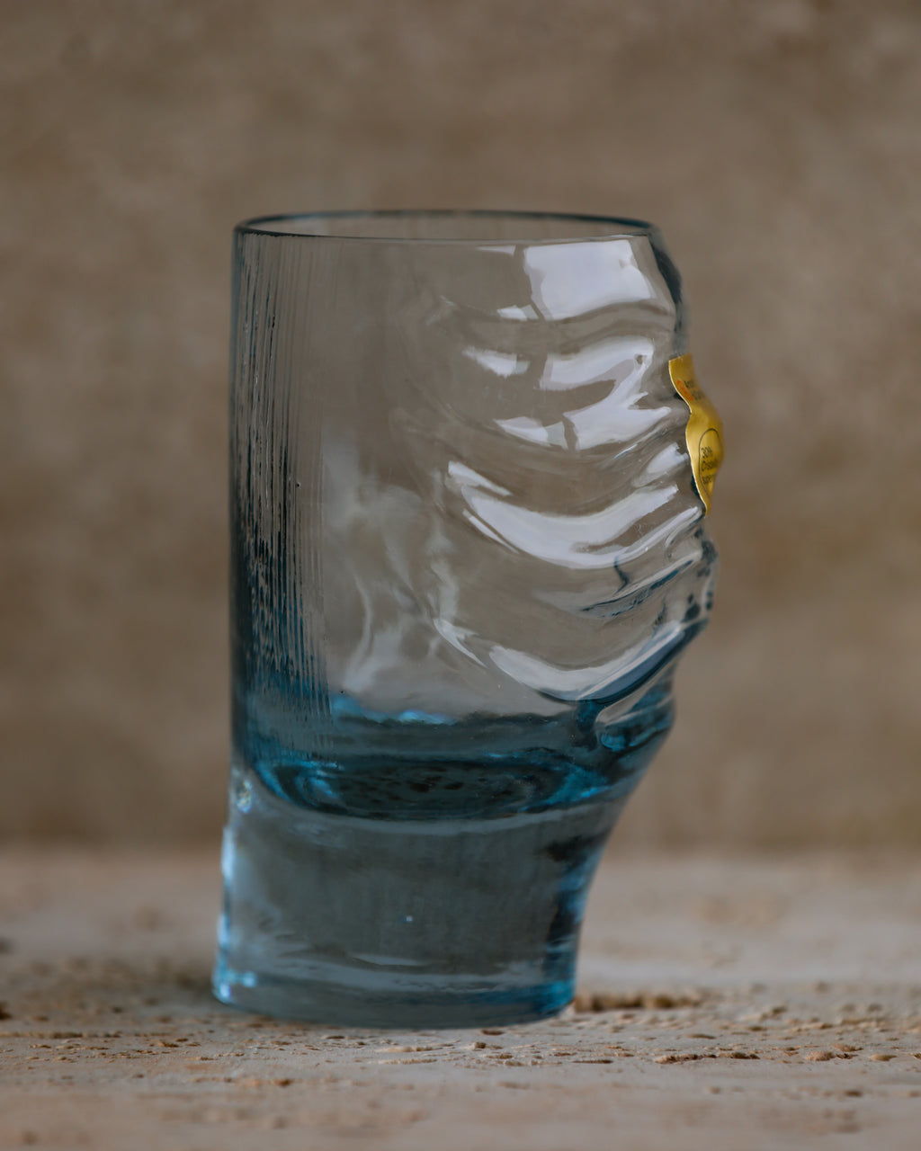 Side-angle shot of sculpted cobalt blue tumbler showing wave-like indentations.