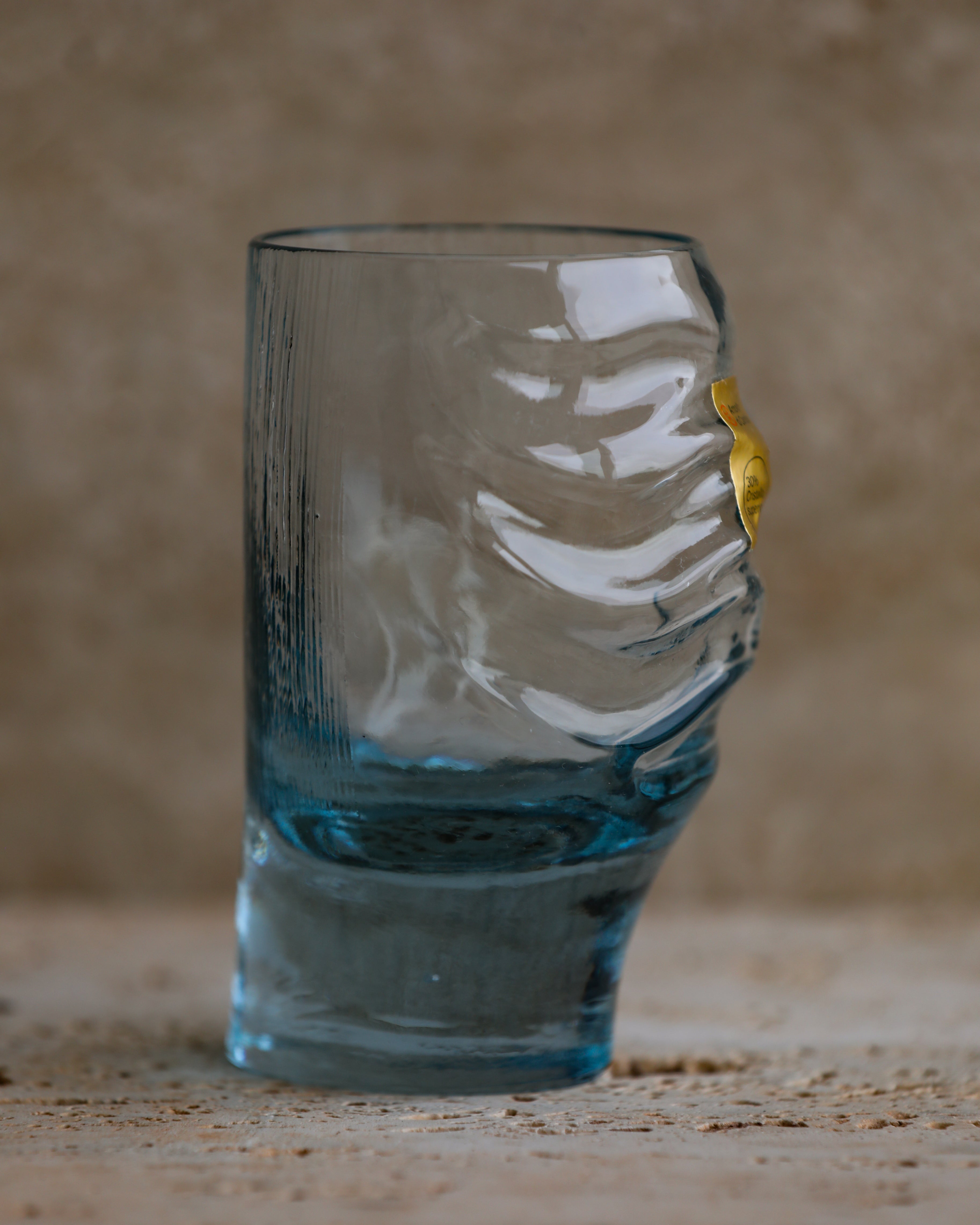 Side-angle shot of sculpted cobalt blue tumbler showing wave-like indentations.