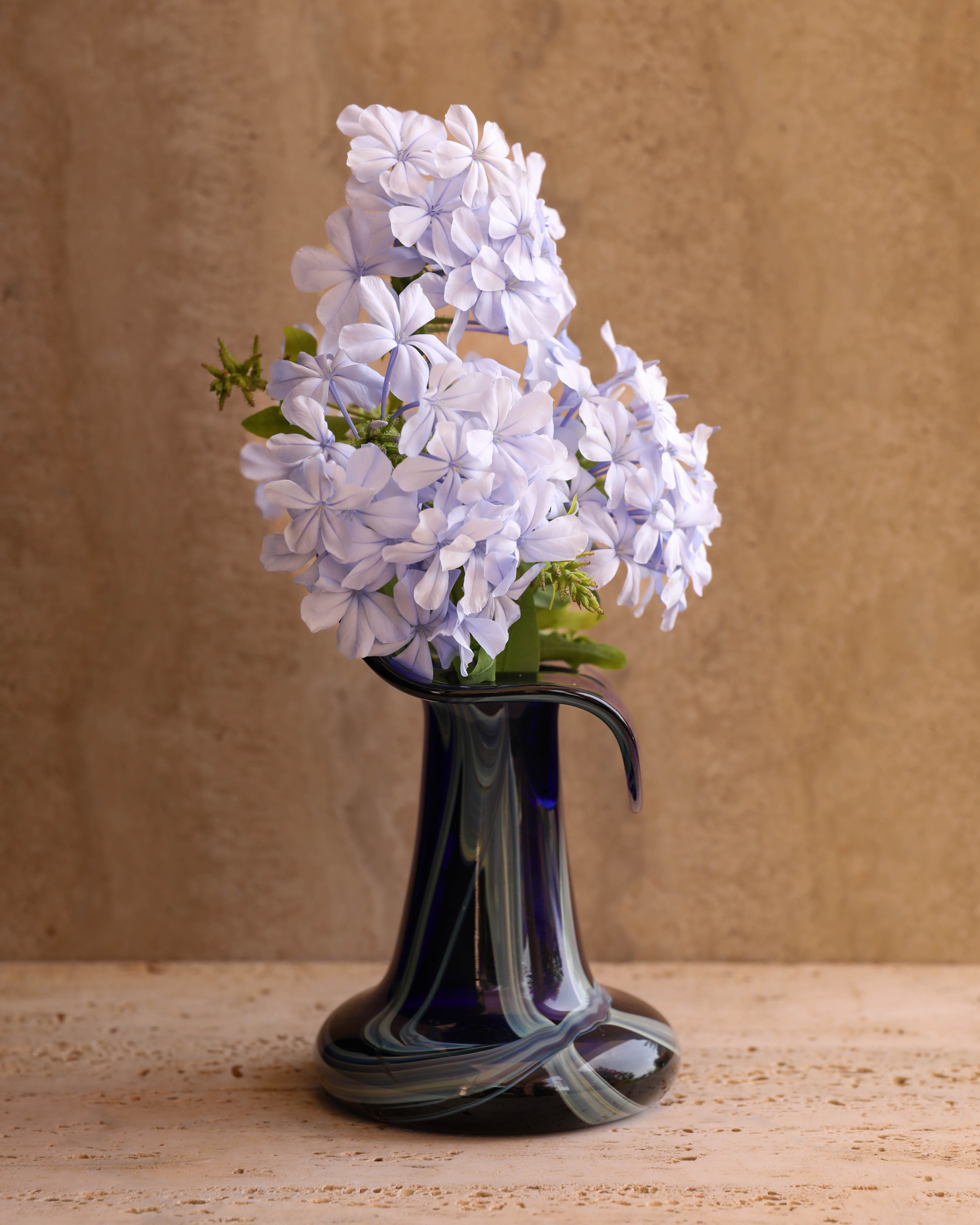 Marta Marzotto cobalt Murano glass vase styled with dried stems on travertine surface — mid-century Italian home decor accent